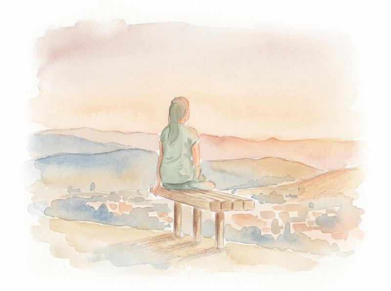 Woman sitting on bench over viewing mountain